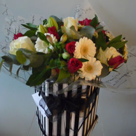 Our stylish vintage hat box filled with 'best available' seasonal flowers.