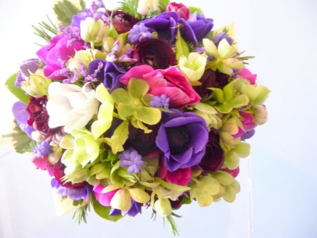 Vibrant spring wedding bouquet of anemones, ranunculus , hellebores and muscari