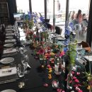 Tablescape of colourful flowers and scattered rose petals
