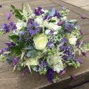 ‘Just picked’ wedding bouquet in blues and whites, consisting of large headed ivory roses, blue nigella flowers, fluffy white astillbe mixed with tiny daisies, scented white freesia and clematis.