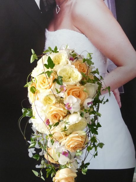 ‘Shower’ style wedding bouquet of scented garden roses, orchids and clematis vine.