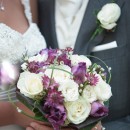 Wedding bouquet of plum coloured tulips and astrantia with ivory roses and tiny wax flowers