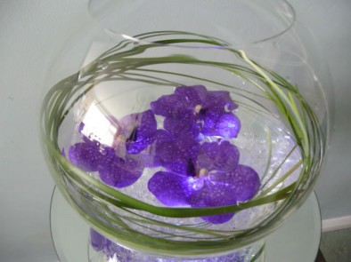 Minimal fish bowl arrangement of floating Vanda blue orchids on crystals
