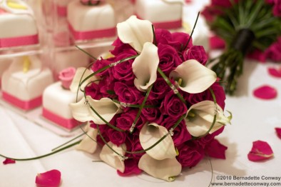 Bridal bouquet of intense cerise pink ‘Milano’ roses with white calla lilies.