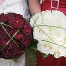 Two compact rose bouquets with grass caging